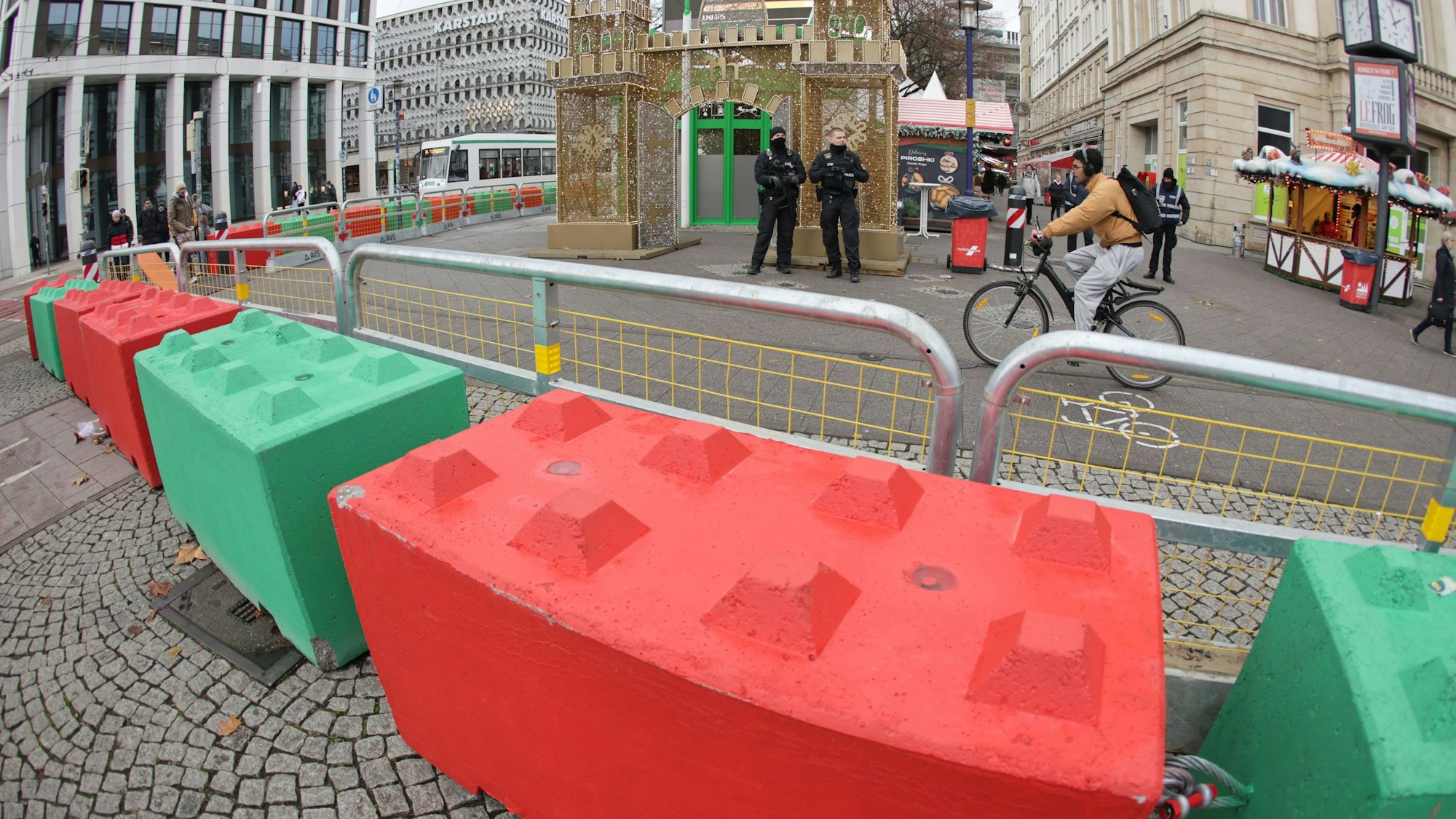 Sollen zum Schutz des Weihnachtsmarktes beitragen: Rot und grün bemalte Betonblöcke liegen in langen Reihen vor den Eingängen zum alten Marktplatz in Magdeburg.