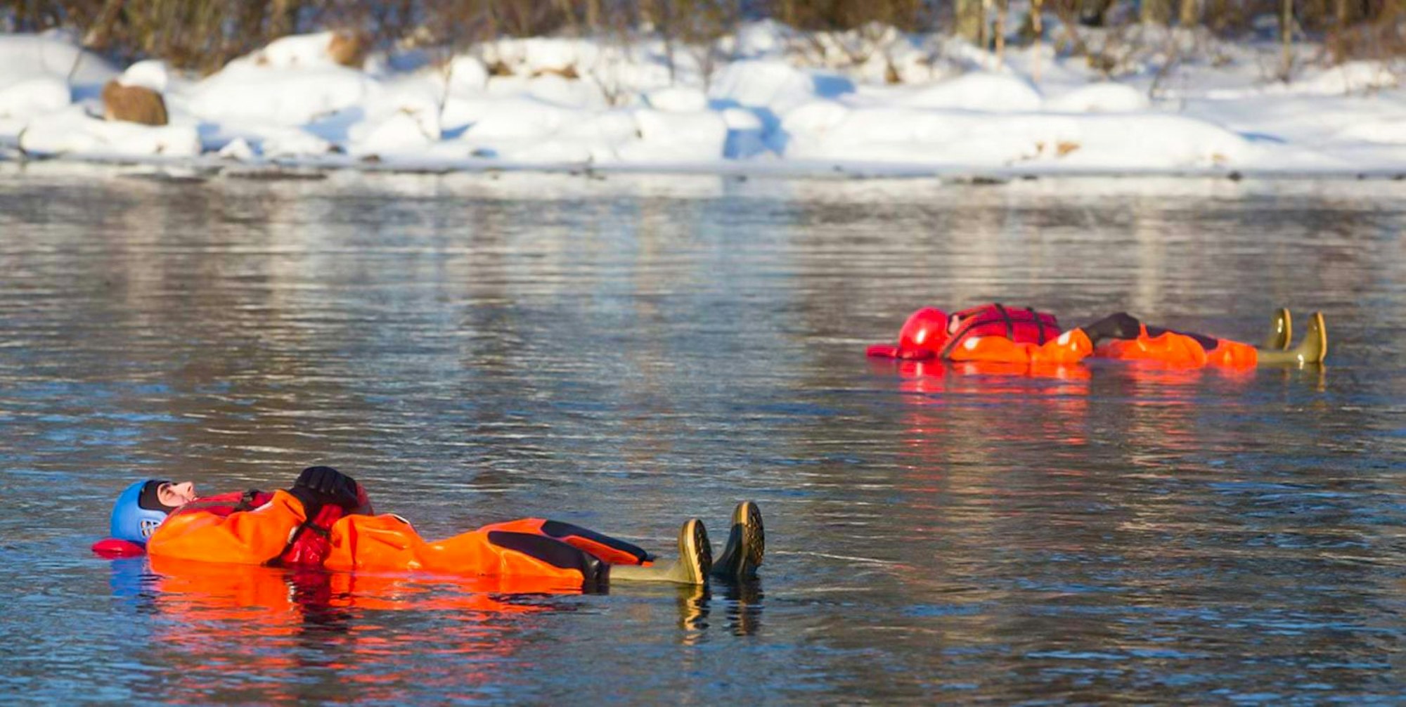 Das Bild zeigt zwei Personen beim Riverfloating, die schwerelos im wärmenden Neopren-Anzug stromabwärts in einem Fluss treiben.