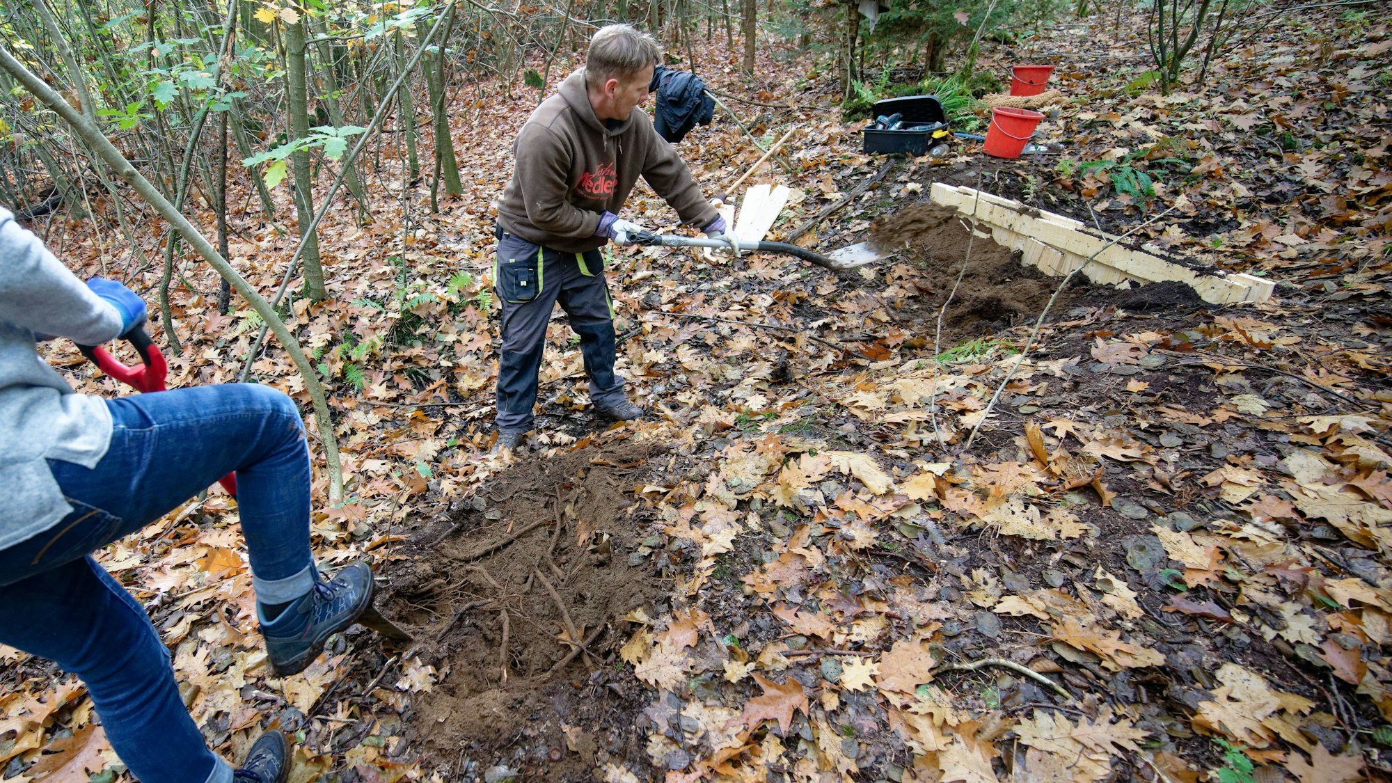 Im Gierather Wald bei Bergisch Gladbach bauen Teilnehmer einen Damm in einem Entwässerungsgraben.