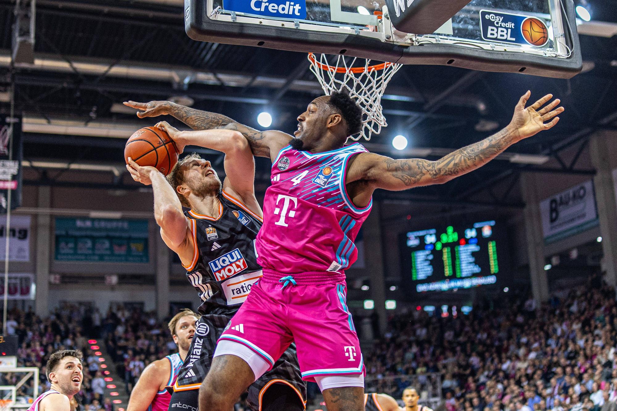 Das Bild zeigt zwei Basketballspieler am Korb.