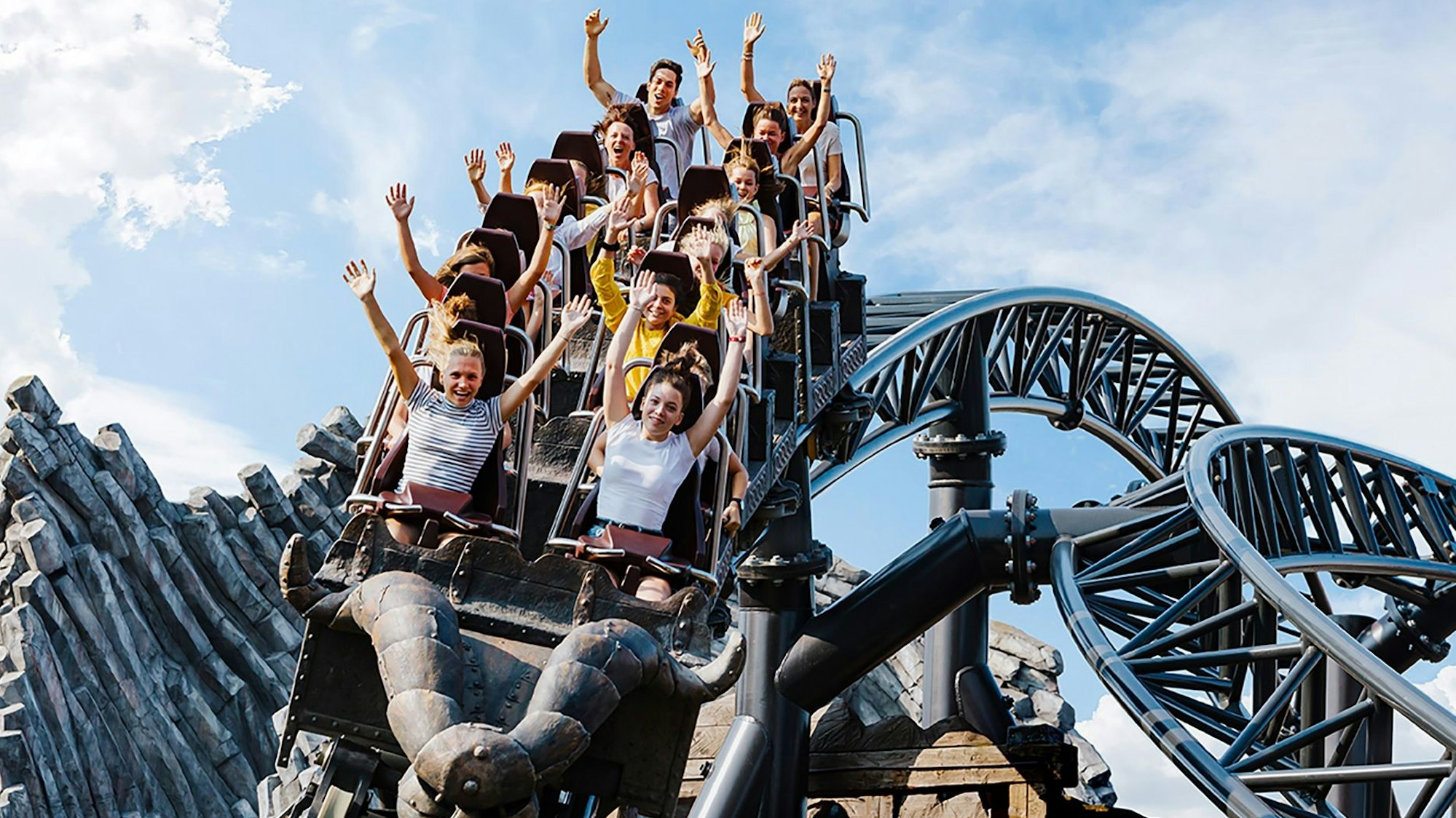 Zu sehen ist eine vollbesetzte Achterbahn.