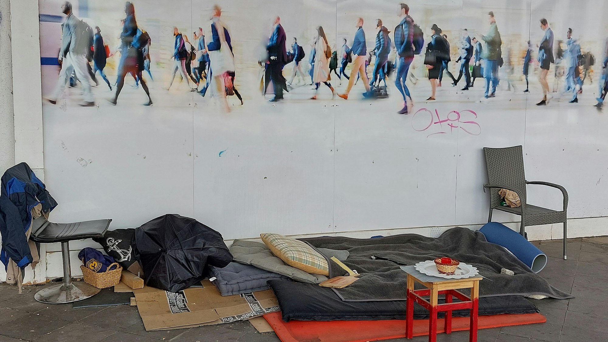 Das Nachtlager eines Obdachlosen vor einer Hauswand.