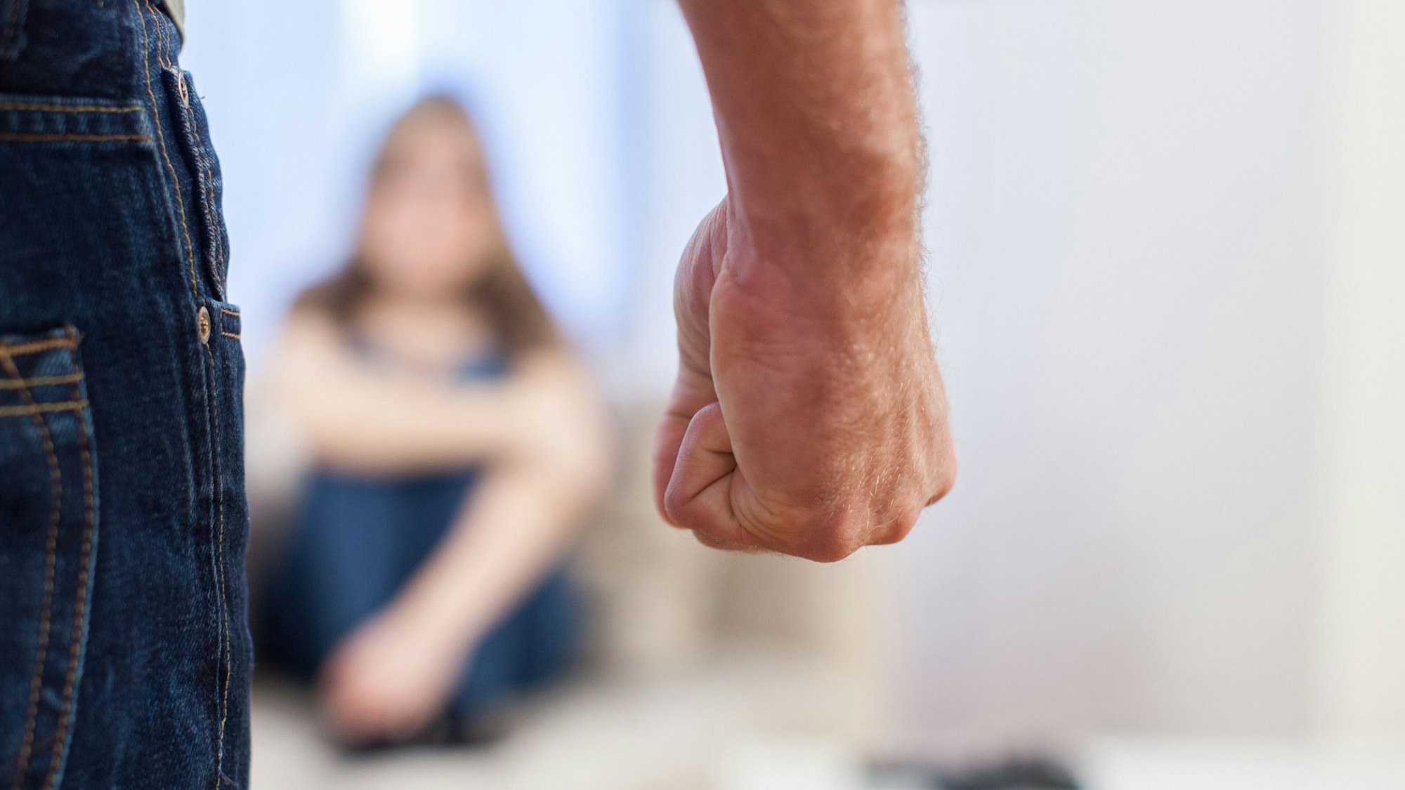 Symbolbild: Mann bedroht Frau mit geballter Faust.