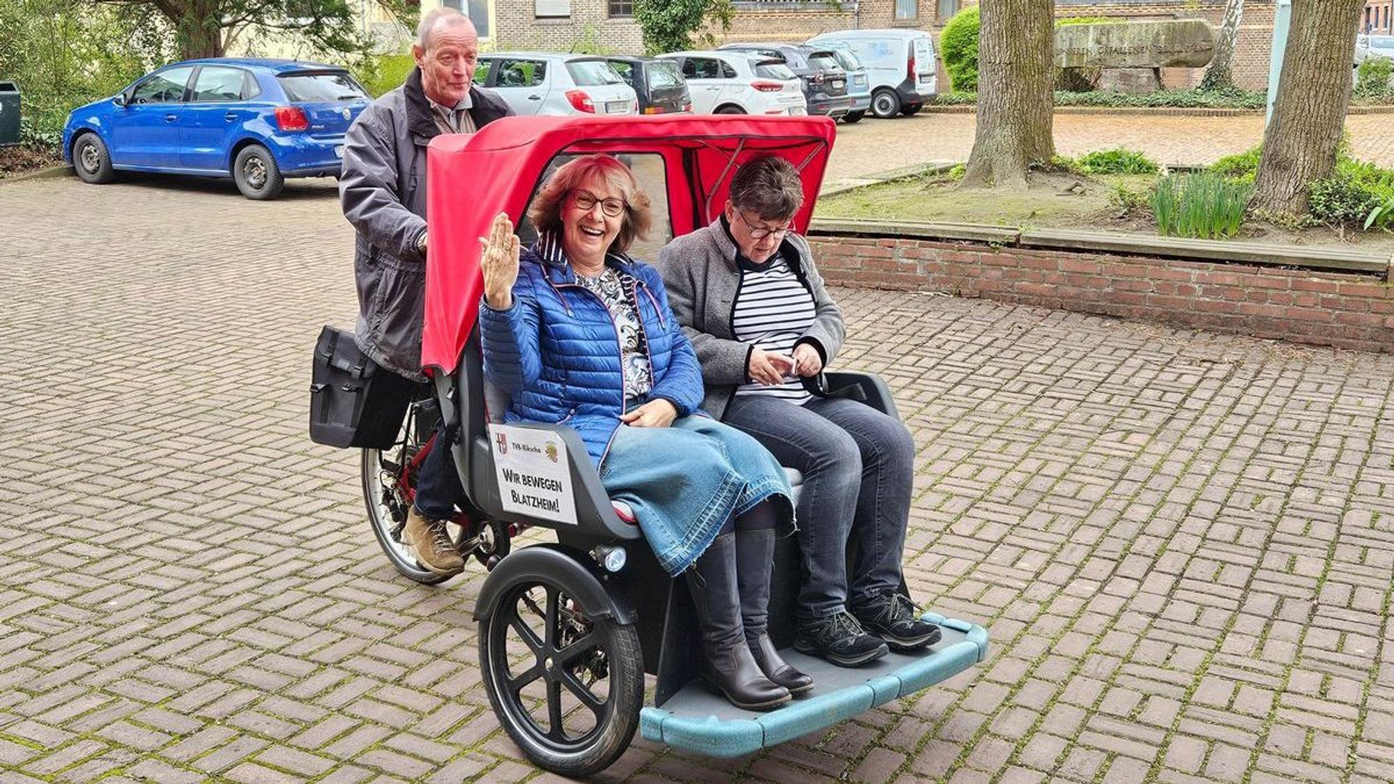 Das Foto zeigt Menschen in einer Fahrrad-Rikscha.