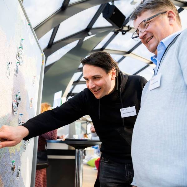 Das Foto zeigt zwei Männer, einer von ihnen zeigt auf einer Deutschlandkarte auf Oberberg