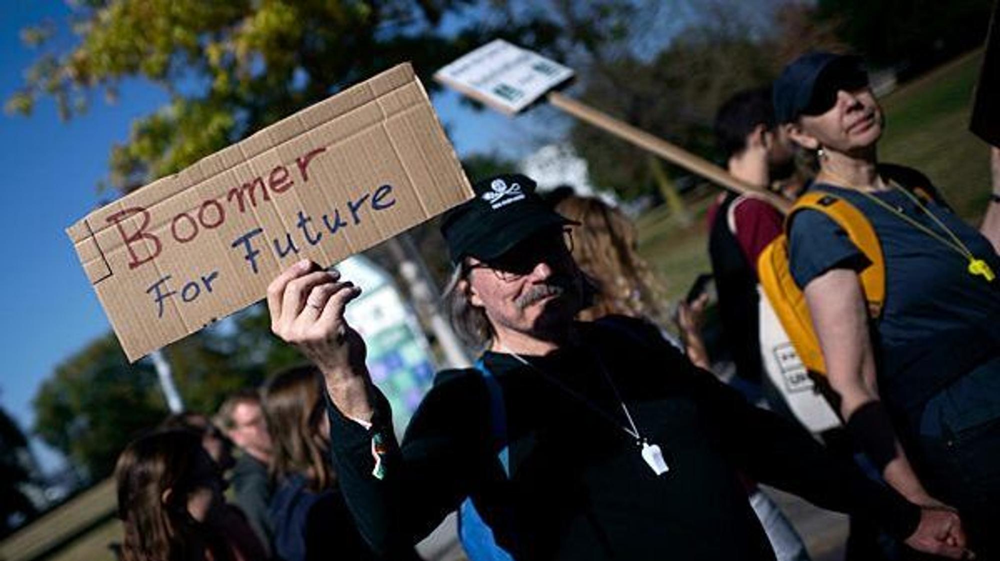 Demonstranten der Fridays For Future Bewegung mit Schild Generation Boomer for Future