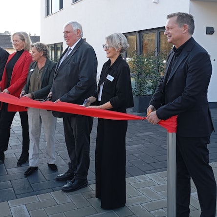 Das Foto zeigt Menschen, die ein rotes Band zerschneiden.