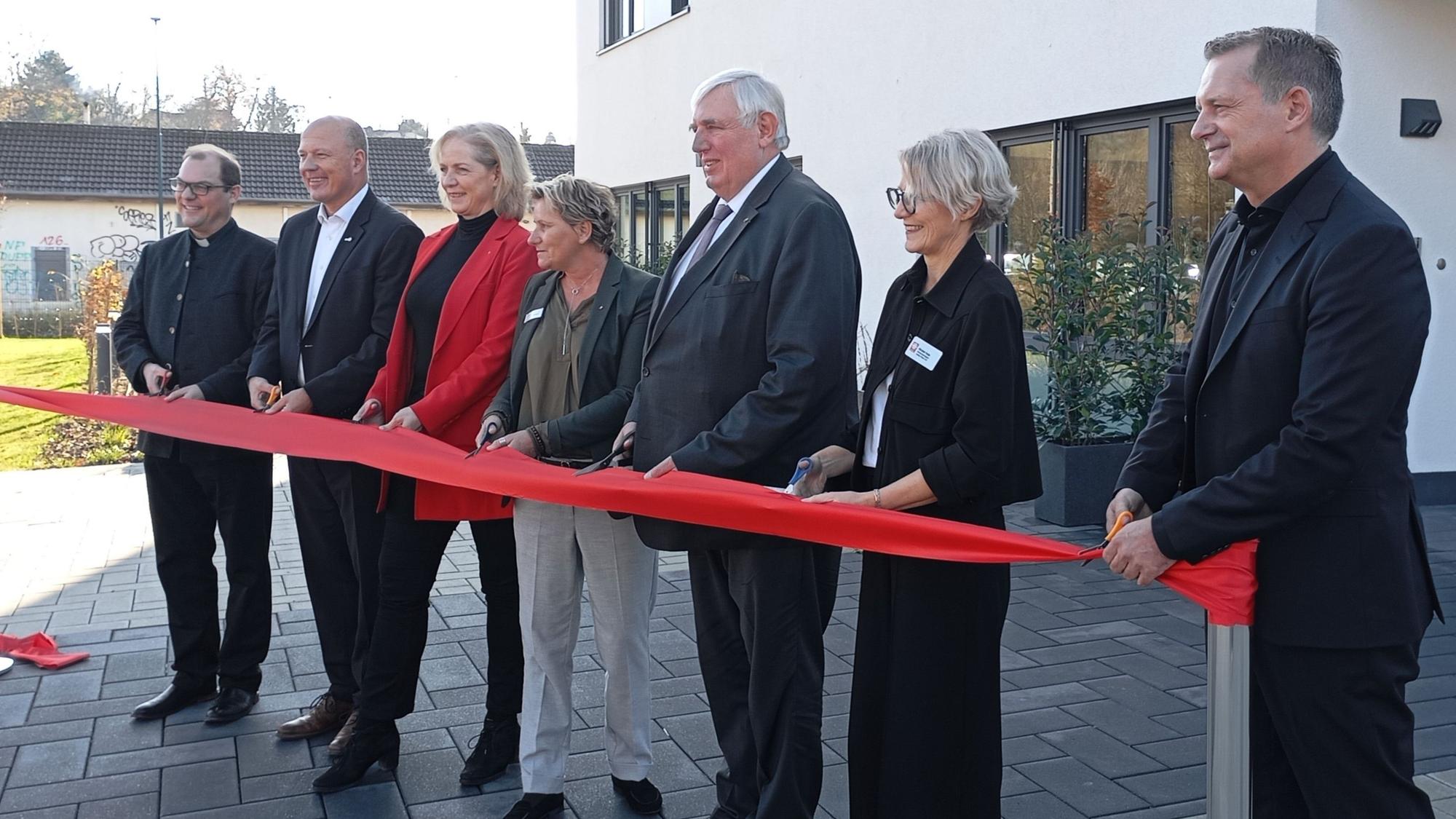 Das Foto zeigt Menschen, die ein rotes Band zerschneiden.