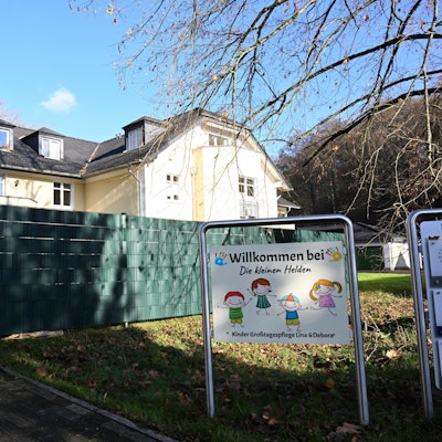 Ein Haus, davor ein Sichtschutz und ein Schild mit der Aufschrift: Willkommen bei „Die kleinen Helden“