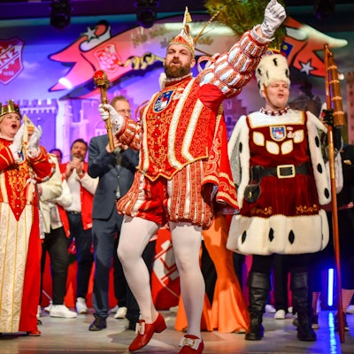 Ein Dreigestirn steht auf einer Bühne.