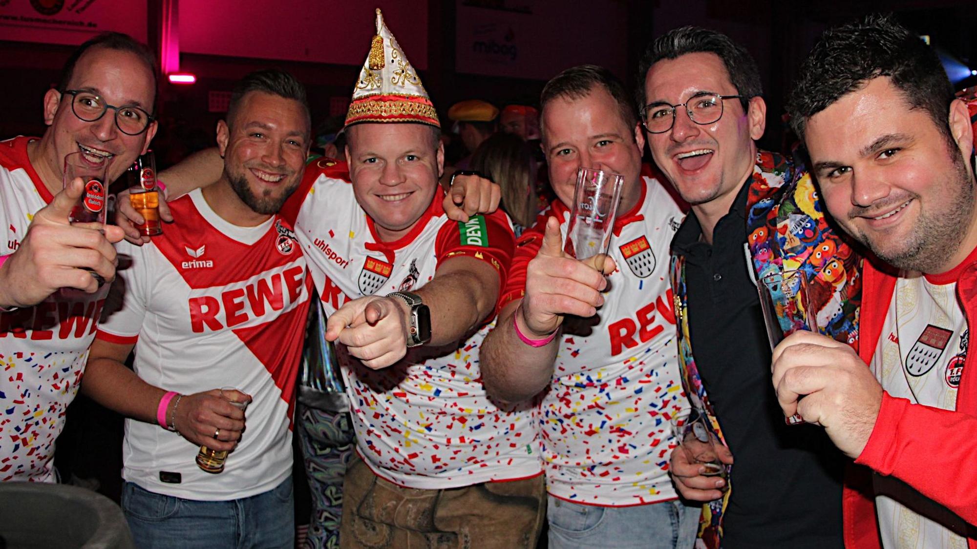 Sechs Männer, zum Teil in Trikots der 1. FC Köln, feiern.