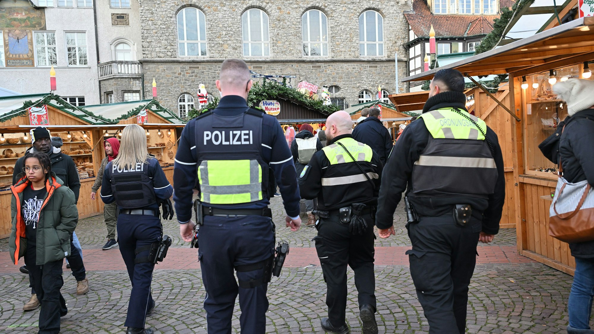 Polizei und Ordnungsamt patrouilliert über einen Weihnachtsmarkt.