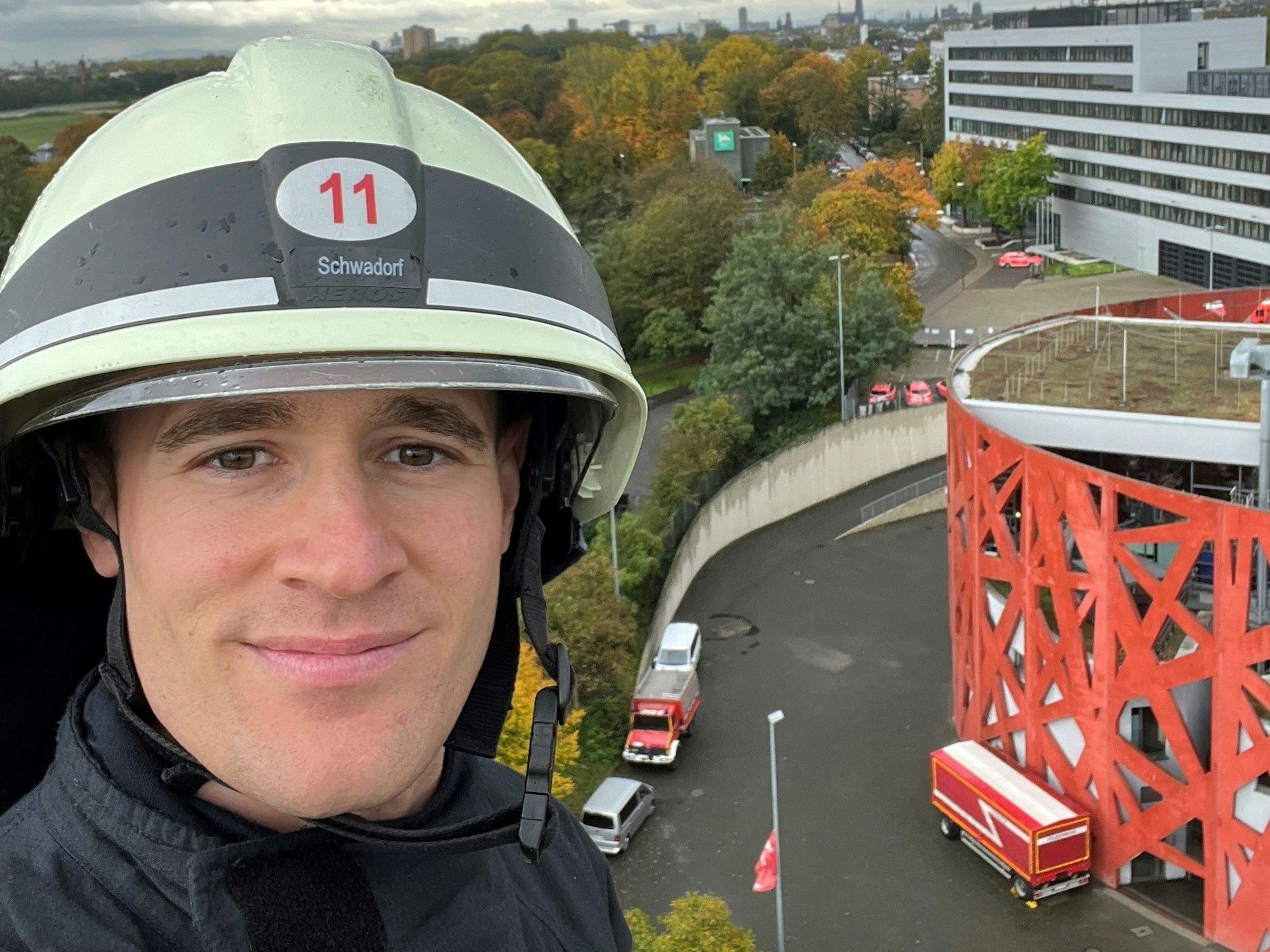Das Foto zeigt einen Feuerwehrmann, auf dessen Helm sein Name Schwadorf steht, in großer Höhe.