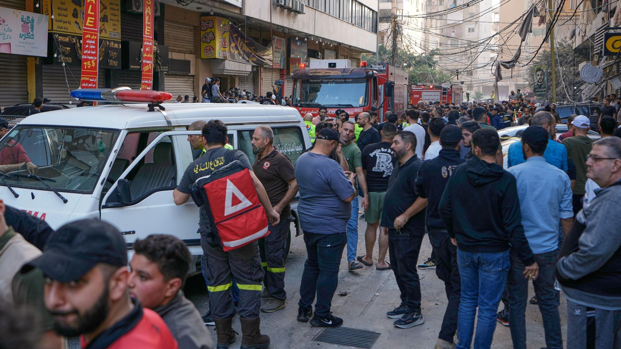 Menschen und Mitarbeiter des Zivilschutzes versammeln sich an dem Ort, nachdem ein Wohnhaus bei einem israelischen Luftangriff im südlichen Vorort von Beirut getroffen hat.