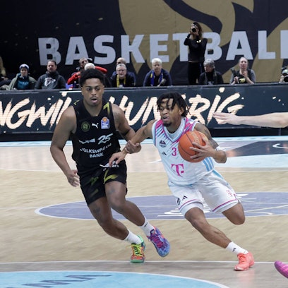 Bonns Aufbauspieler Zach Cooks zieht gegen die Braunschweiger Grant Sherfield (links) und Benny Schröder (rechts) zum Korb.