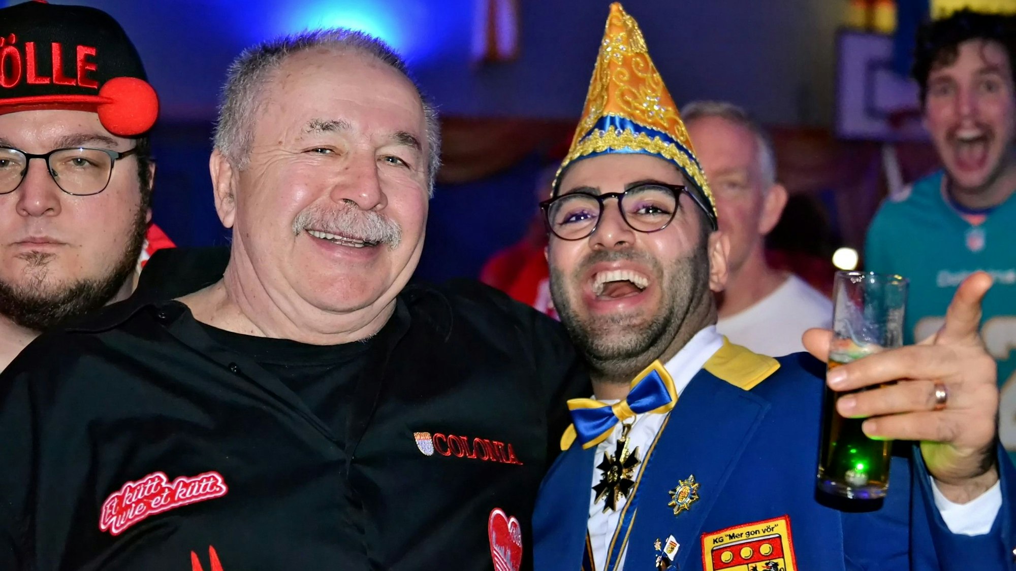 Zwei Jecken liegen sich in den Armen und feiern.