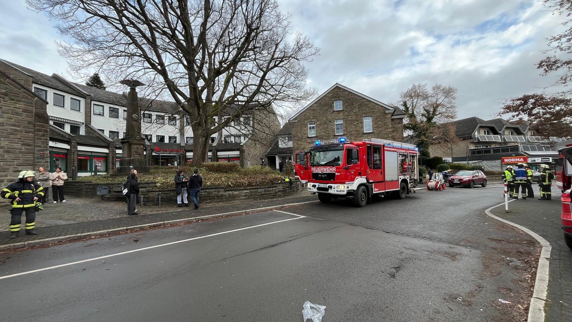 Das Foto zeigt ein Feuerwehrauto und Einsatzkräfte der Feuerwehr in Lindlar, vor der Geschäftsstelle der Kreissparkasse Köln