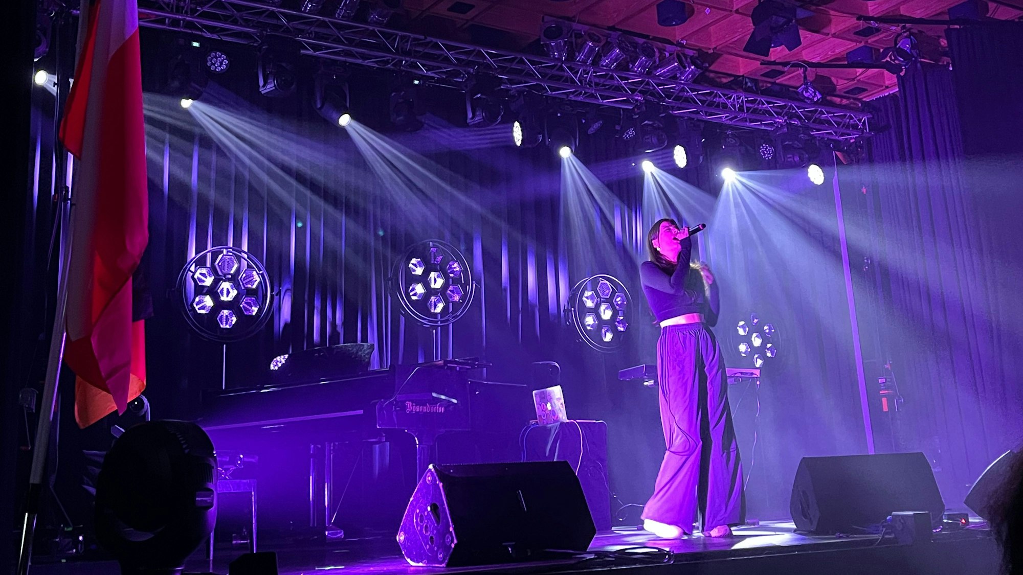 Eine junge Frau singt auf einer Bühne.