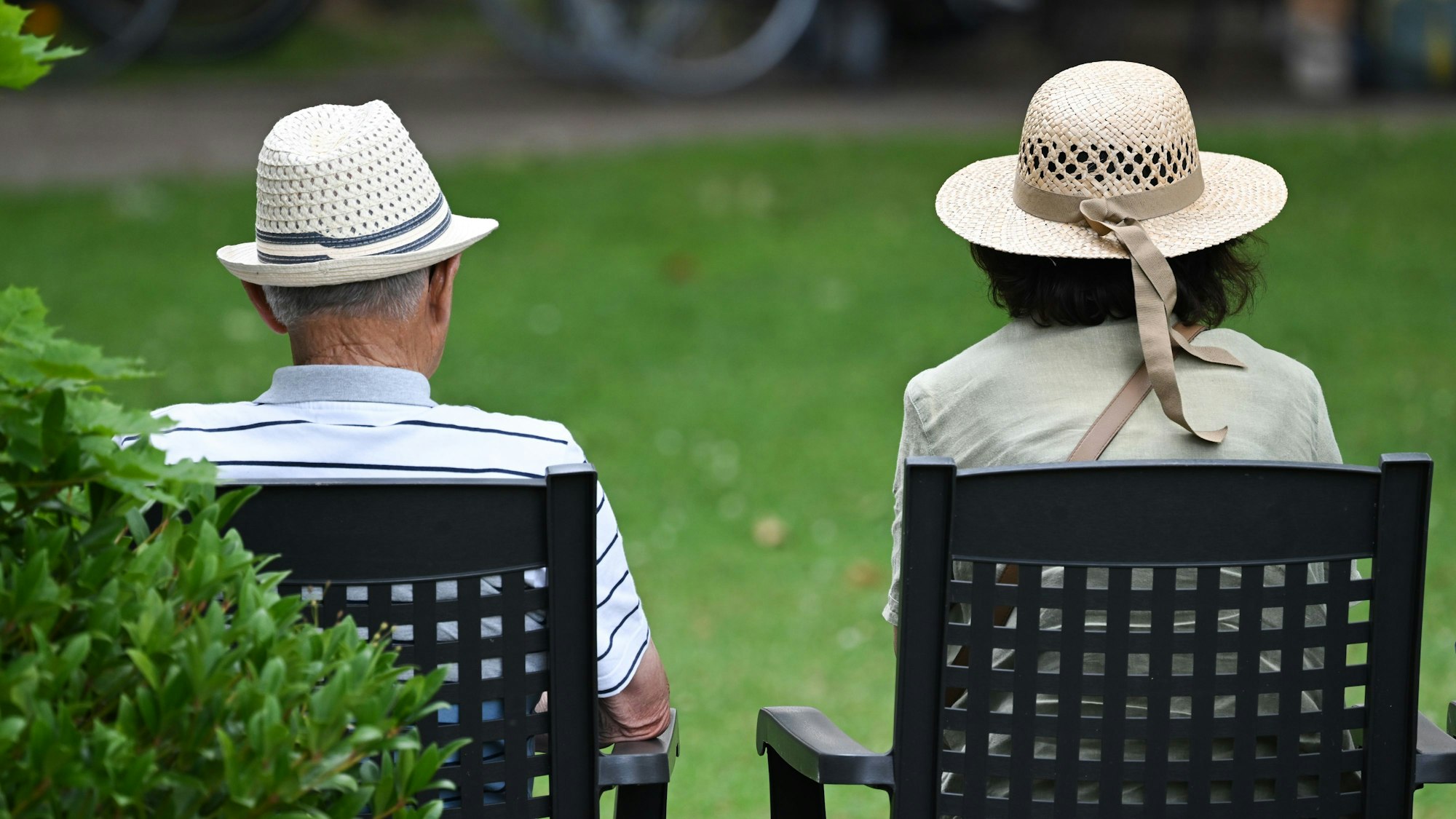 Ein älteres Paar verfolgt im Kurpark das Konzert eines Schulorchesters.