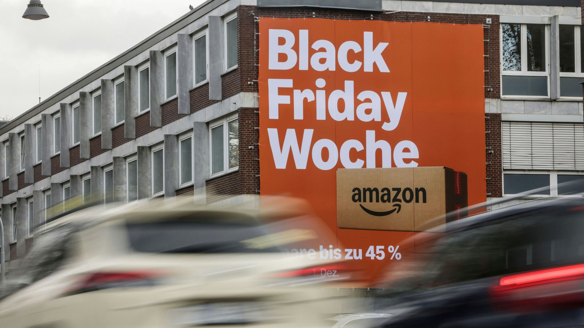 Köln: An der Fassade eines Hauses wird für Rabatte am Black Friday geworben.