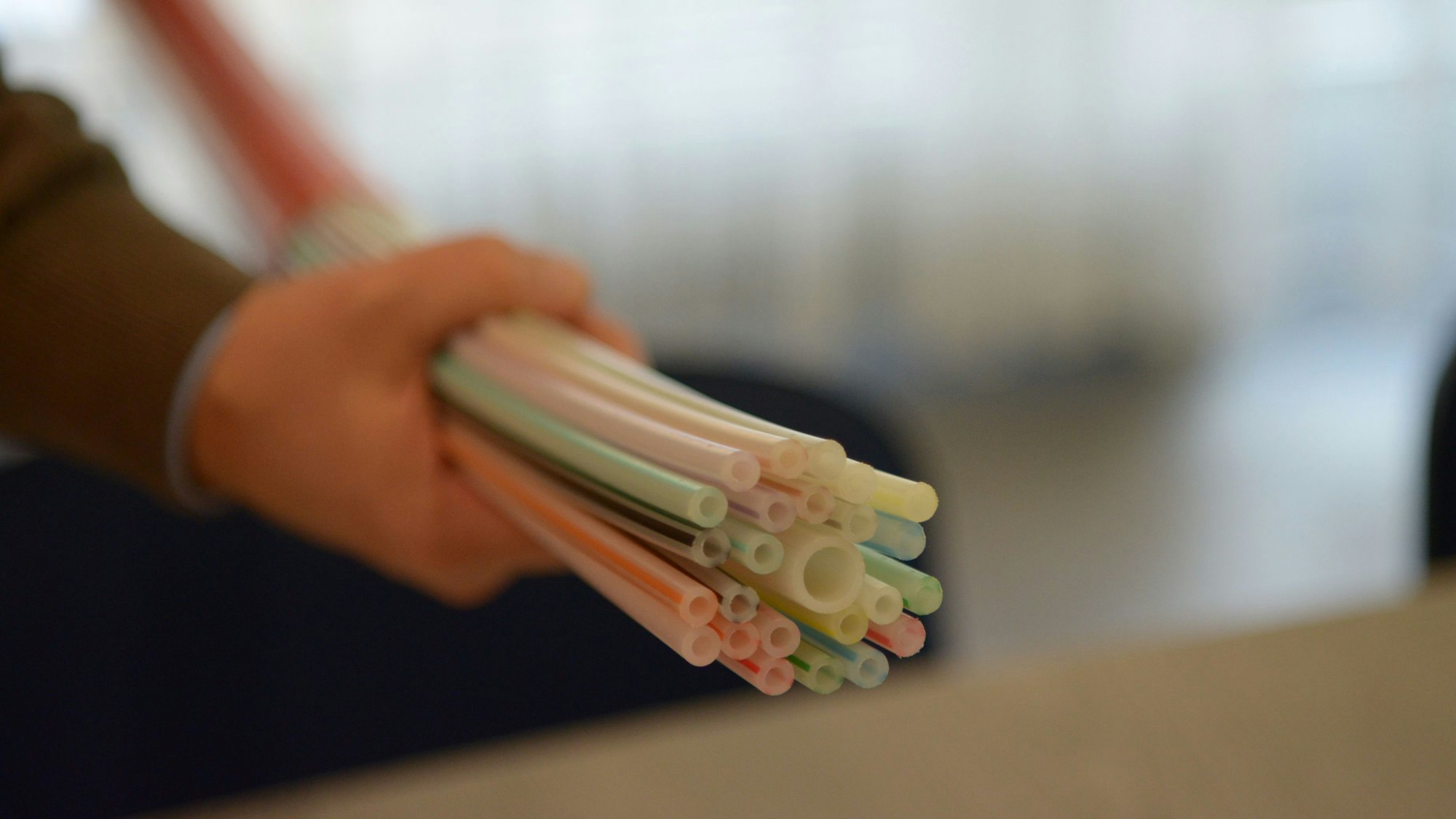 Ein Mann hält einen Glasfaserstrang in der Hand. (Symbolbild)