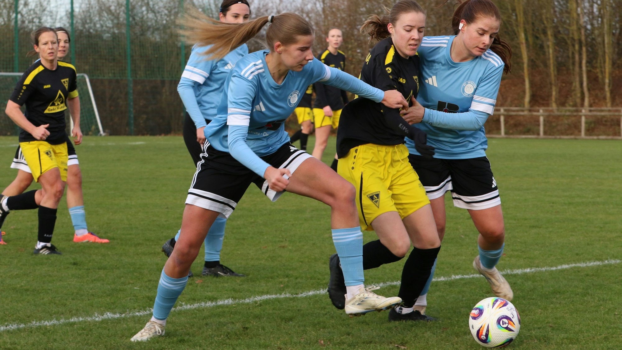 Zwei Verteidigerinnen von Kommern nehmen eine Aachener Spielerin, die den Ball führt, in die Zange – und zwar mit Händen und Füßen.