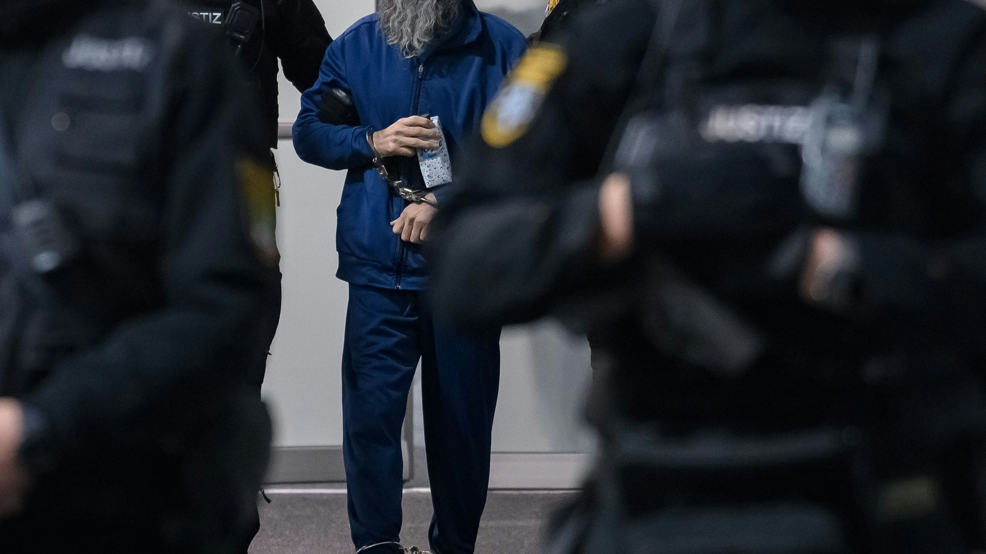 Justizbeamte führen den Angeklagten Taleb al-Abdulmohsen (M) in den Gerichtssaal des temporären Gerichtsgebäude des Landgerichtes Magdeburg. Dort wurde der Prozess gegen den Todesfahrer vom Magdeburger Weihnachtsmarkt fortgesetzt.