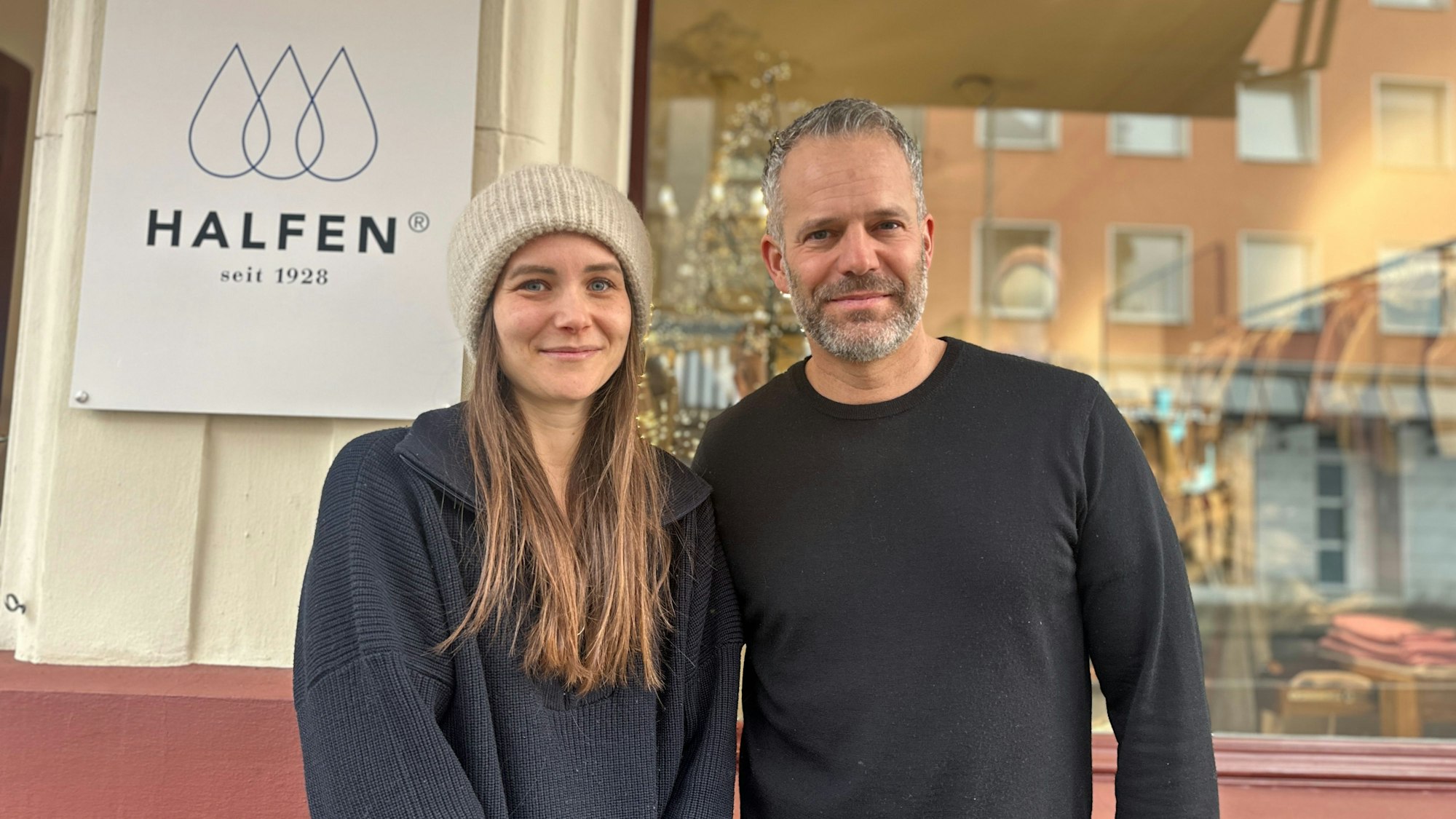 Eine Frau mit langem Haar und Wollmütze steht neben einem Mann mit grauem Haar und Bart.