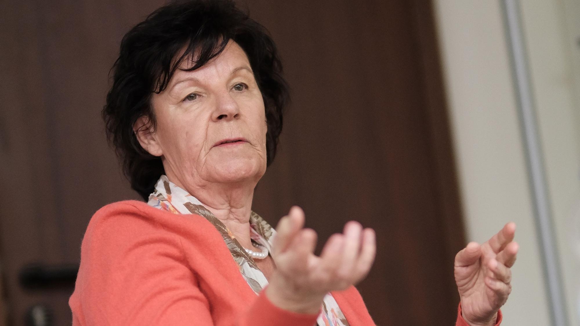 Eine Frau mit schwarzem Haar gestikuliert.