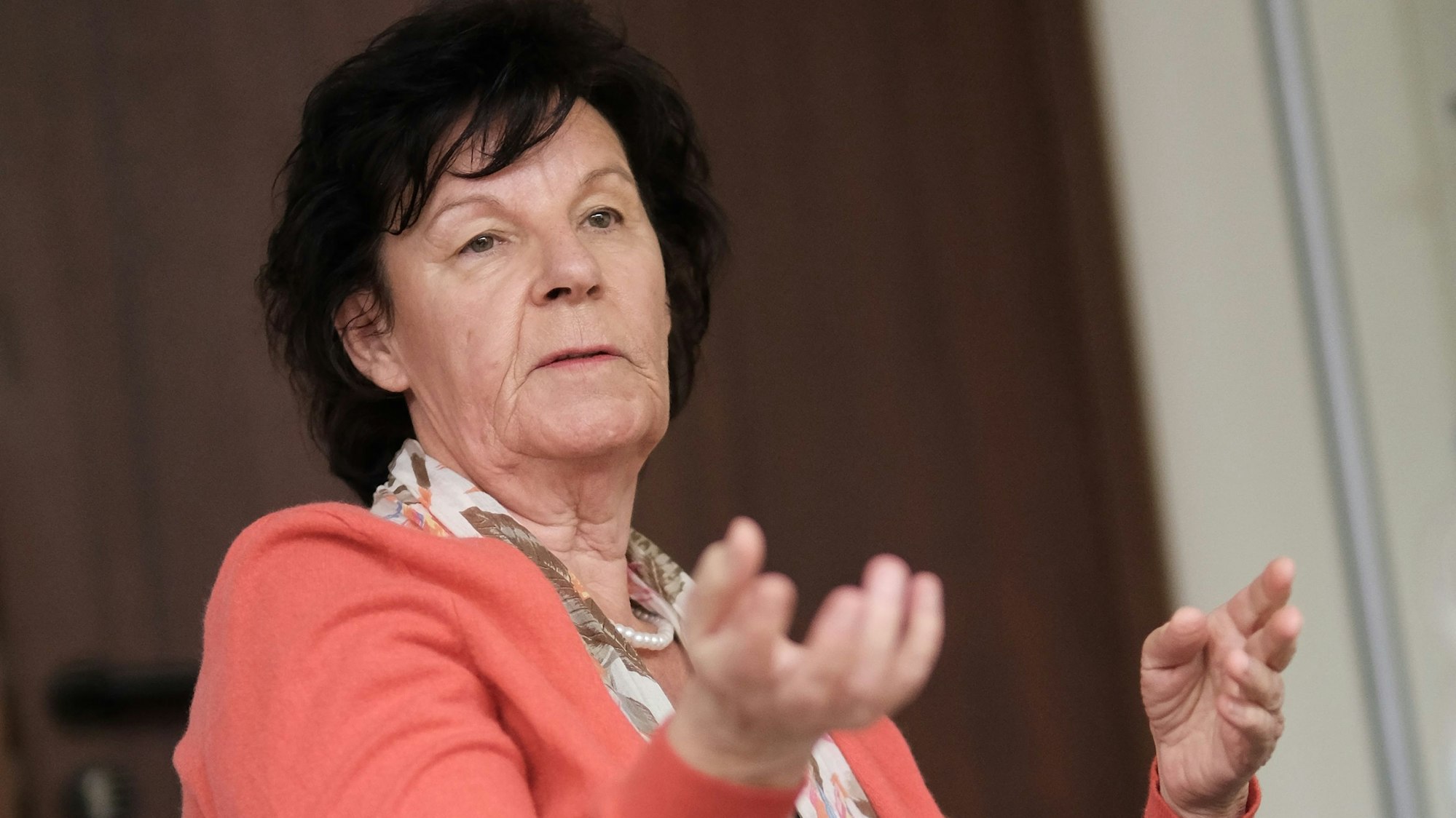 Eine Frau mit schwarzem Haar gestikuliert.