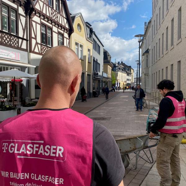 Zu sehen sind Arbeiter, die Westen mit der Aufschrift „Glasfaser“ tragen.
