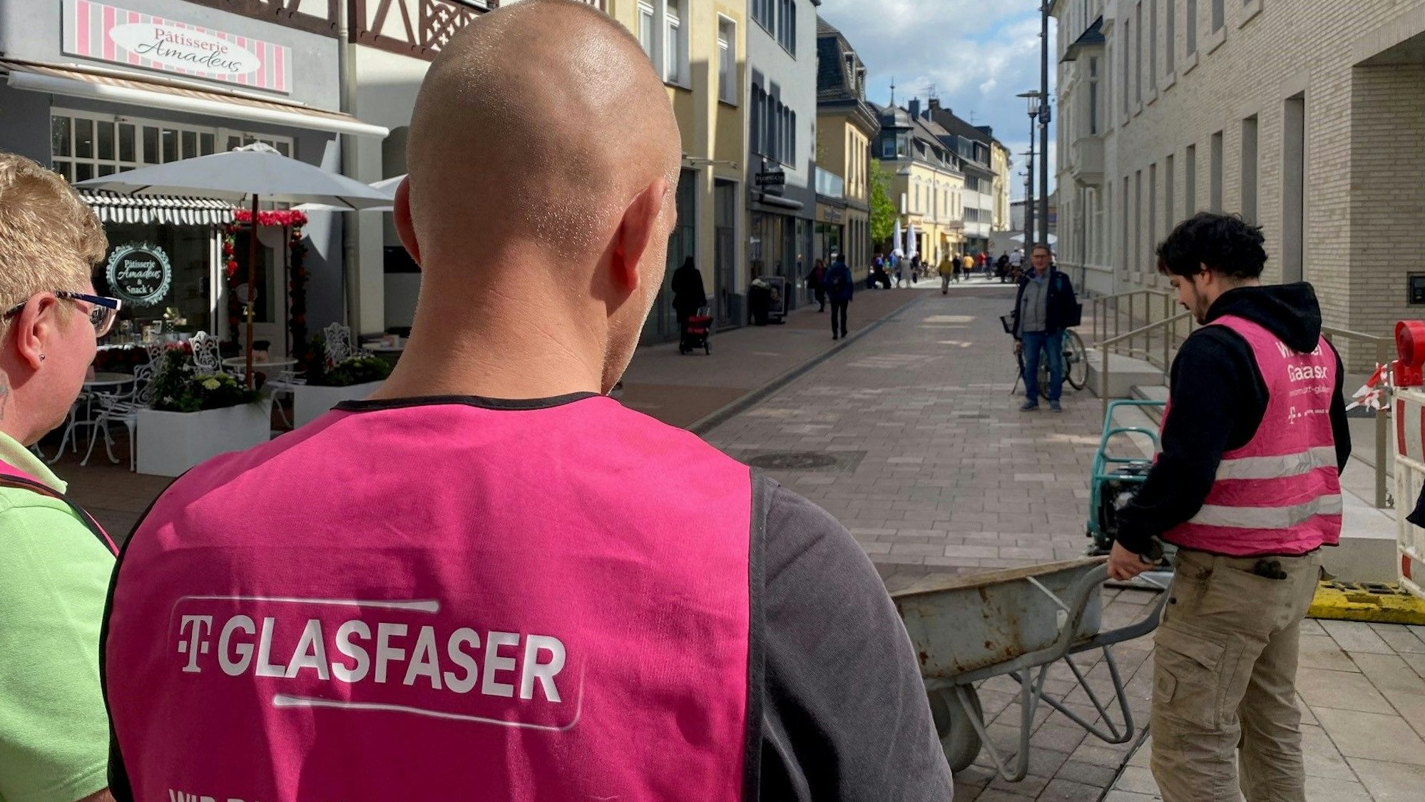 Zu sehen sind Arbeiter, die Westen mit der Aufschrift „Glasfaser“ tragen.