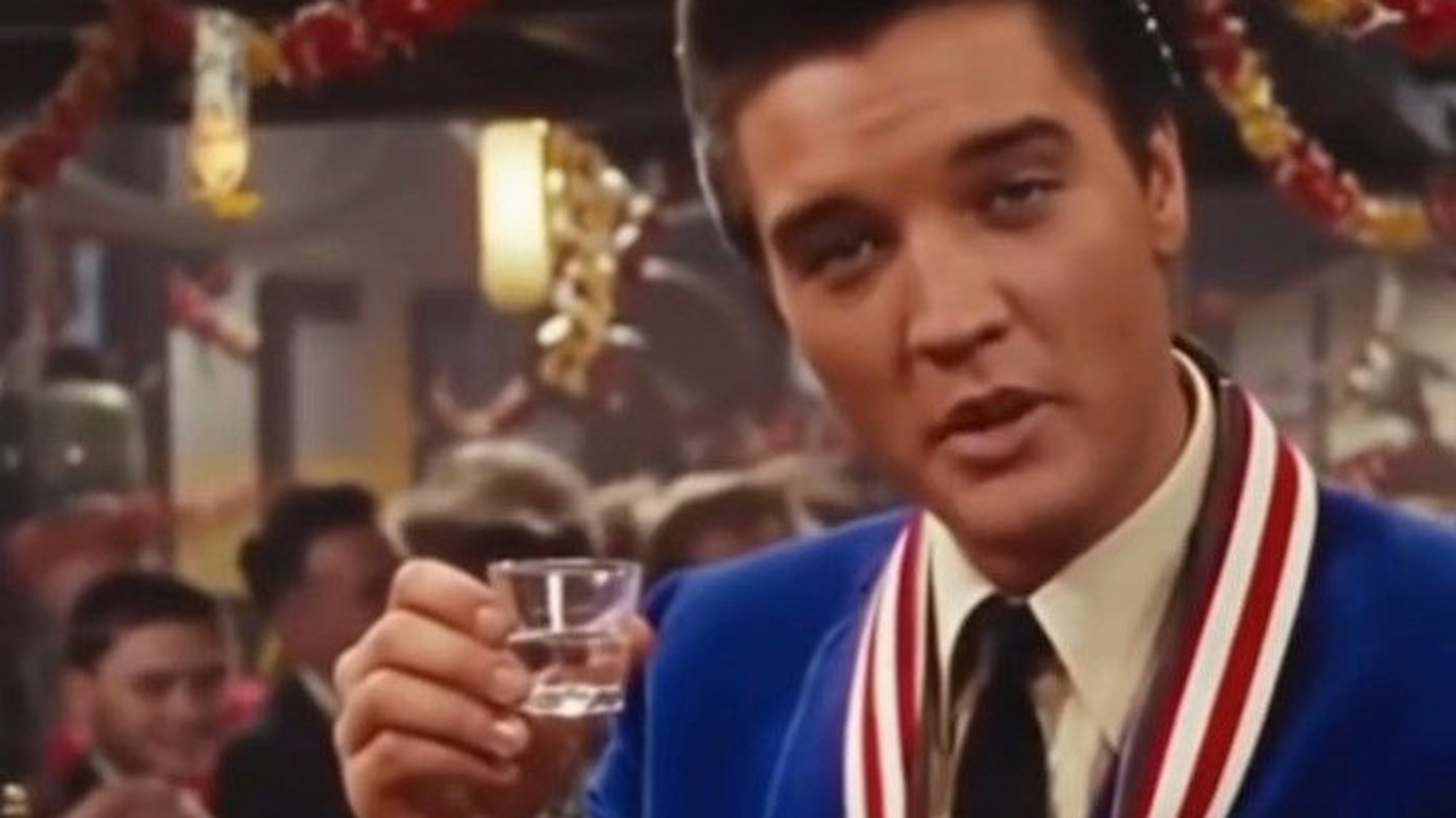 Elvis in einer Kölner Kneipe mit einem Gläschen Schabau. KI-generiert.