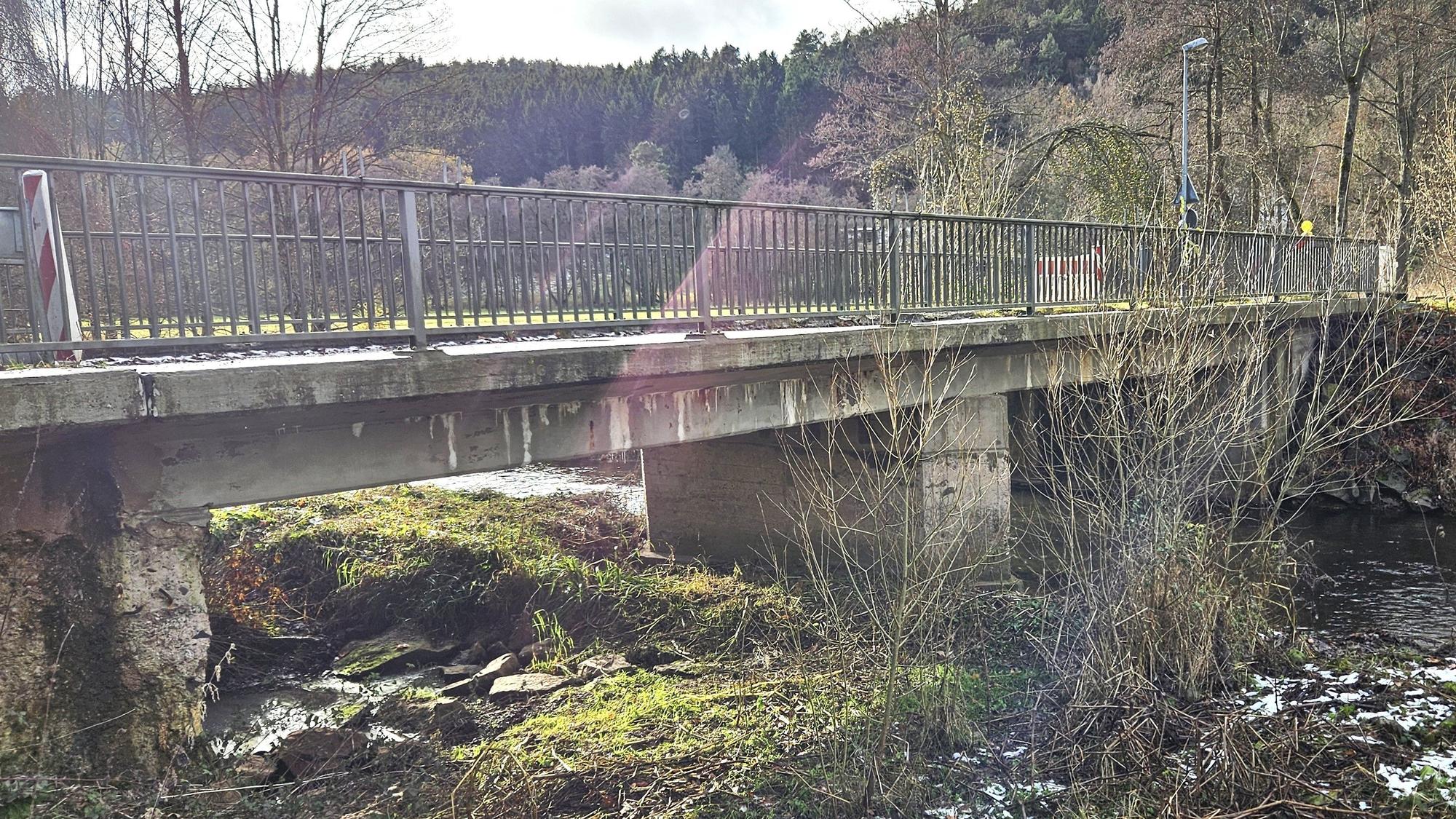 Blick von der Seite auf die alte Brücke, die bei Anstois über die Urft führt.