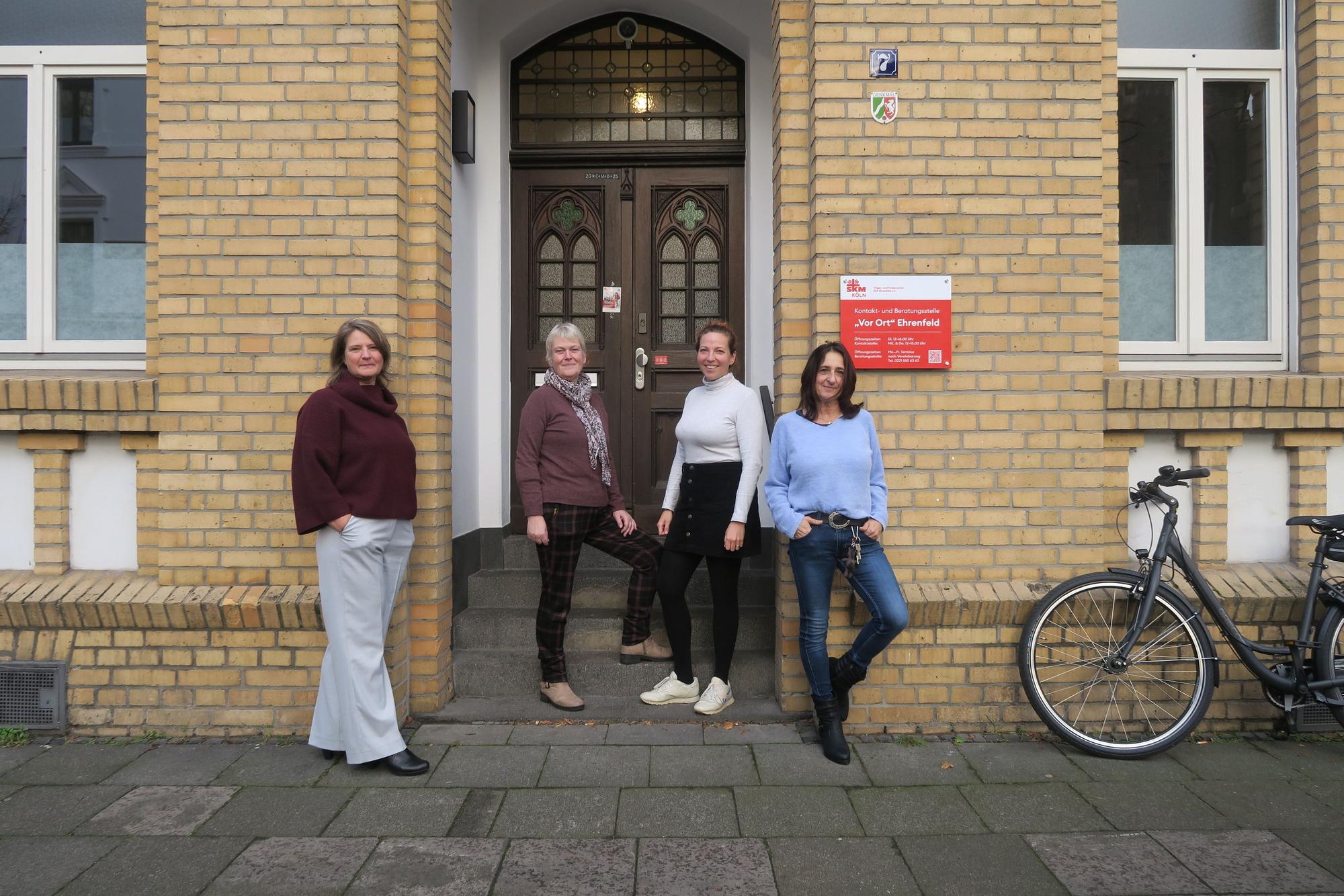 Vier Frauen stehen vor der Tür eines Altbaus.