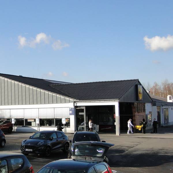 Auf einem Parkplatz vor einem Lidl-Markt stehen viele Autos.