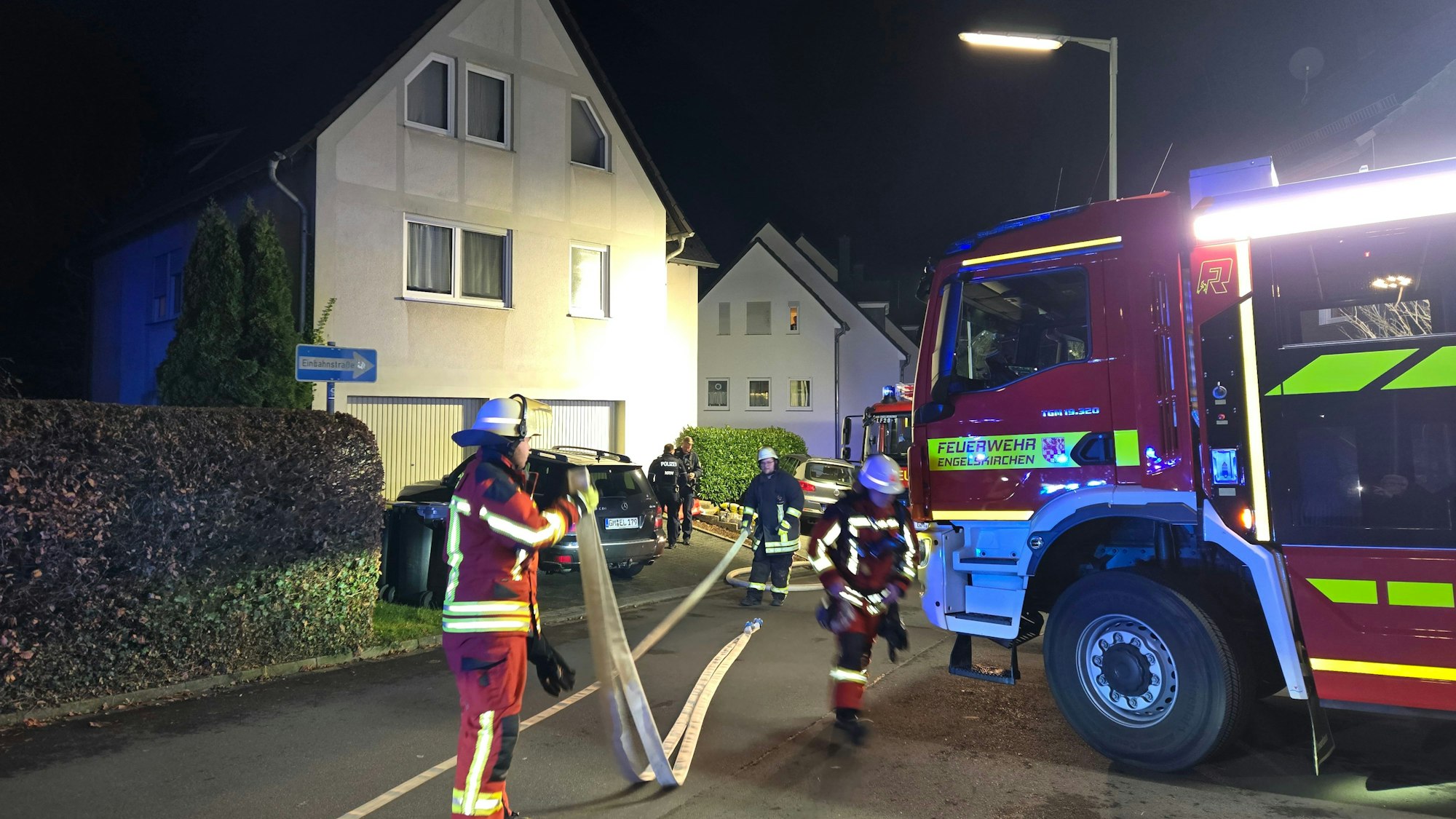 Feuerwehrleute vor einem Wohnhaus.