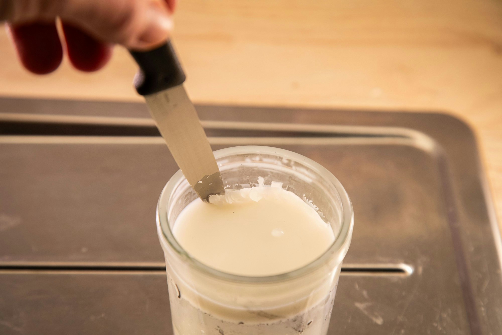 Schritt 2: Das Wachs aushärten lassen und mit einem Messer aus dem Glas herausbrechen.