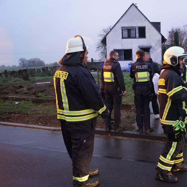 Das Bild zeigt Feuerwehrleute und Polizisten vor dem Einfamilienhaus.