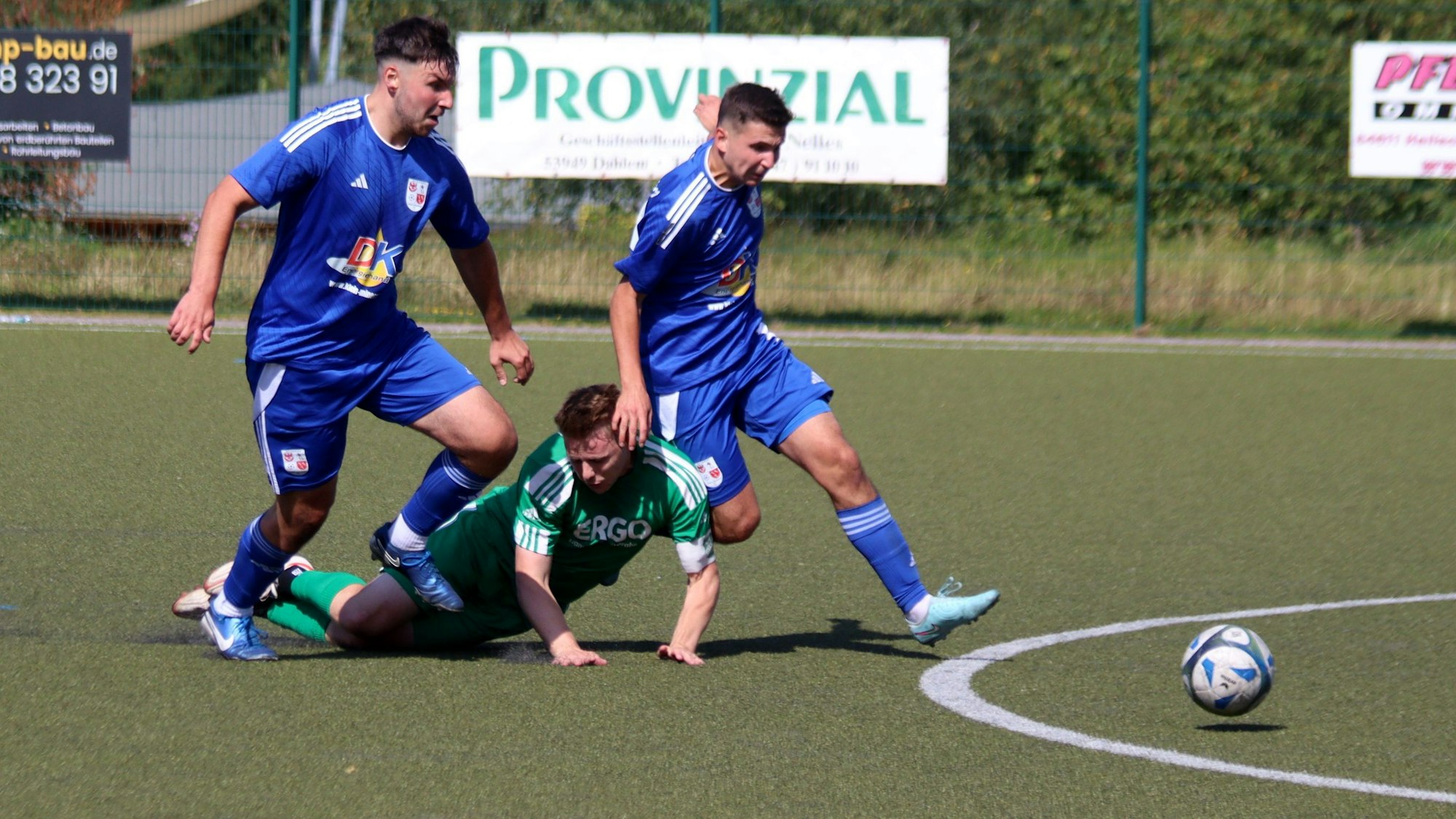 Der Sötenicher Jens Knebel kommt zwischen zwei Spielern von Dahlem-Schmidtheim zu Fall.