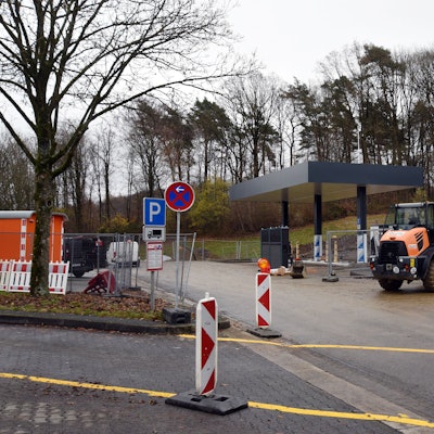 Das Foto zeigt im Bau befindliche Schnellladesäulen für Elektroautos, die mit einem Dach ausgerüstet sind.