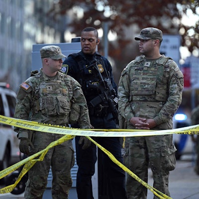 Zwei Nationalgardisten und ein Beamter des Department of Homeland Security sichern in Washington nach einer Schießerei eine Straße.