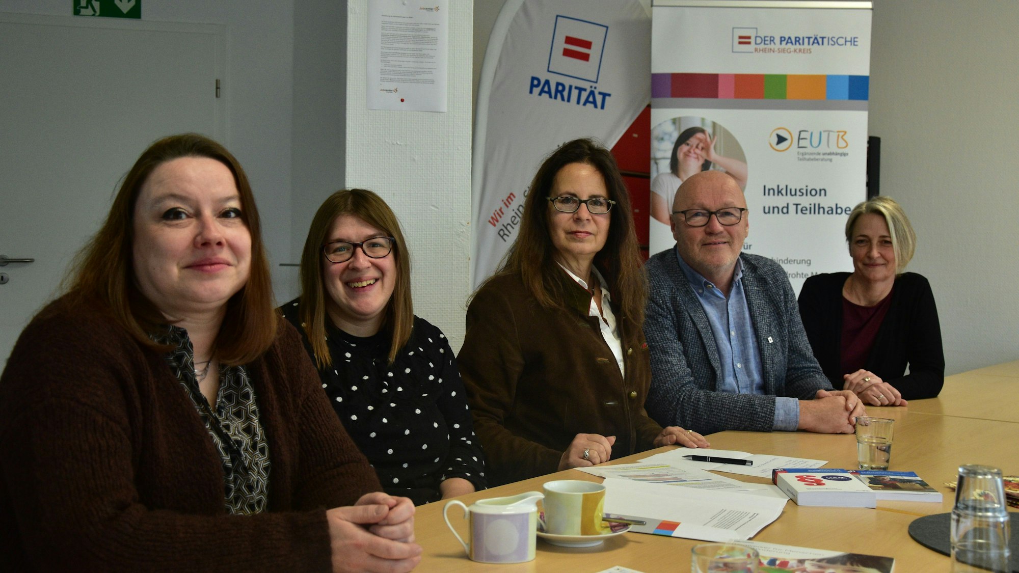 Vier Frauen und ein Mann sitzen an einem Tisch.