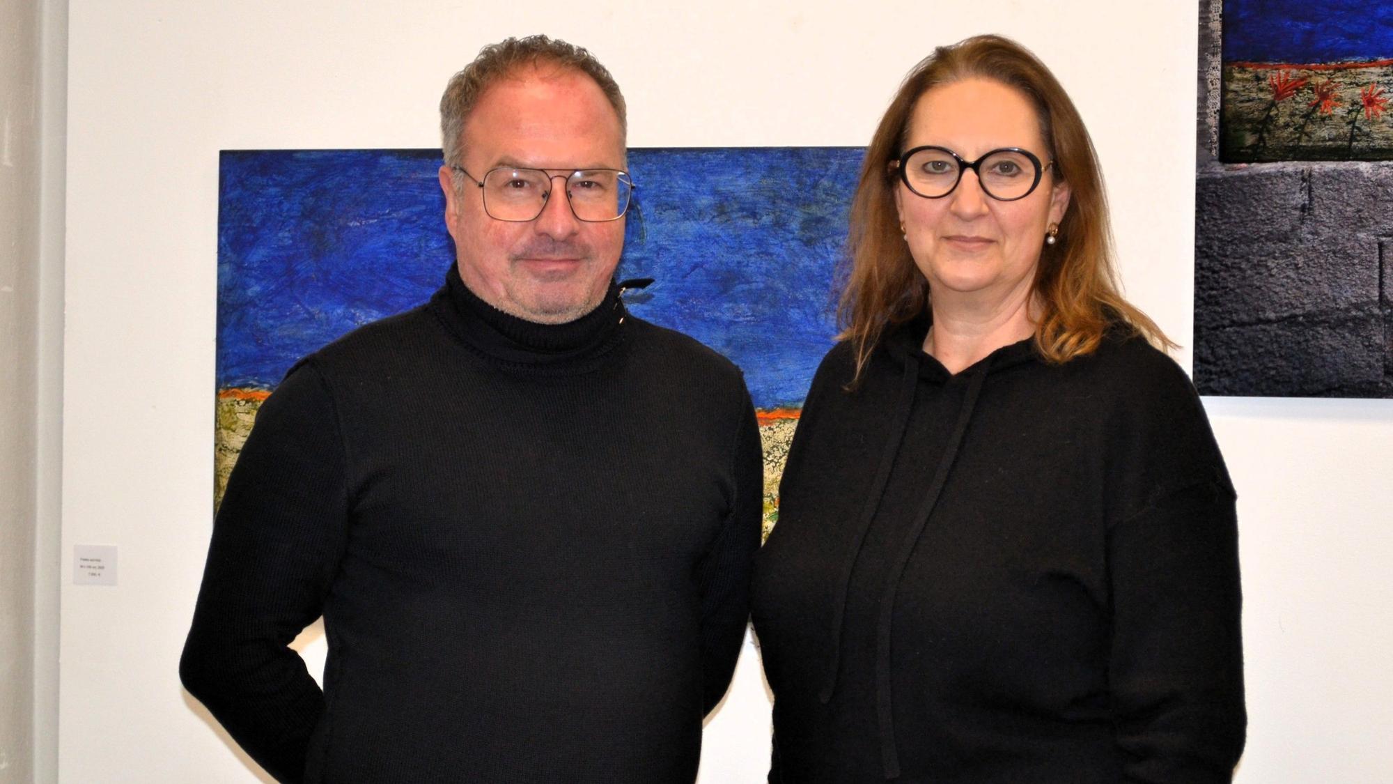 Ein Mann und eine Frau vor einer Wand mit Gemälden