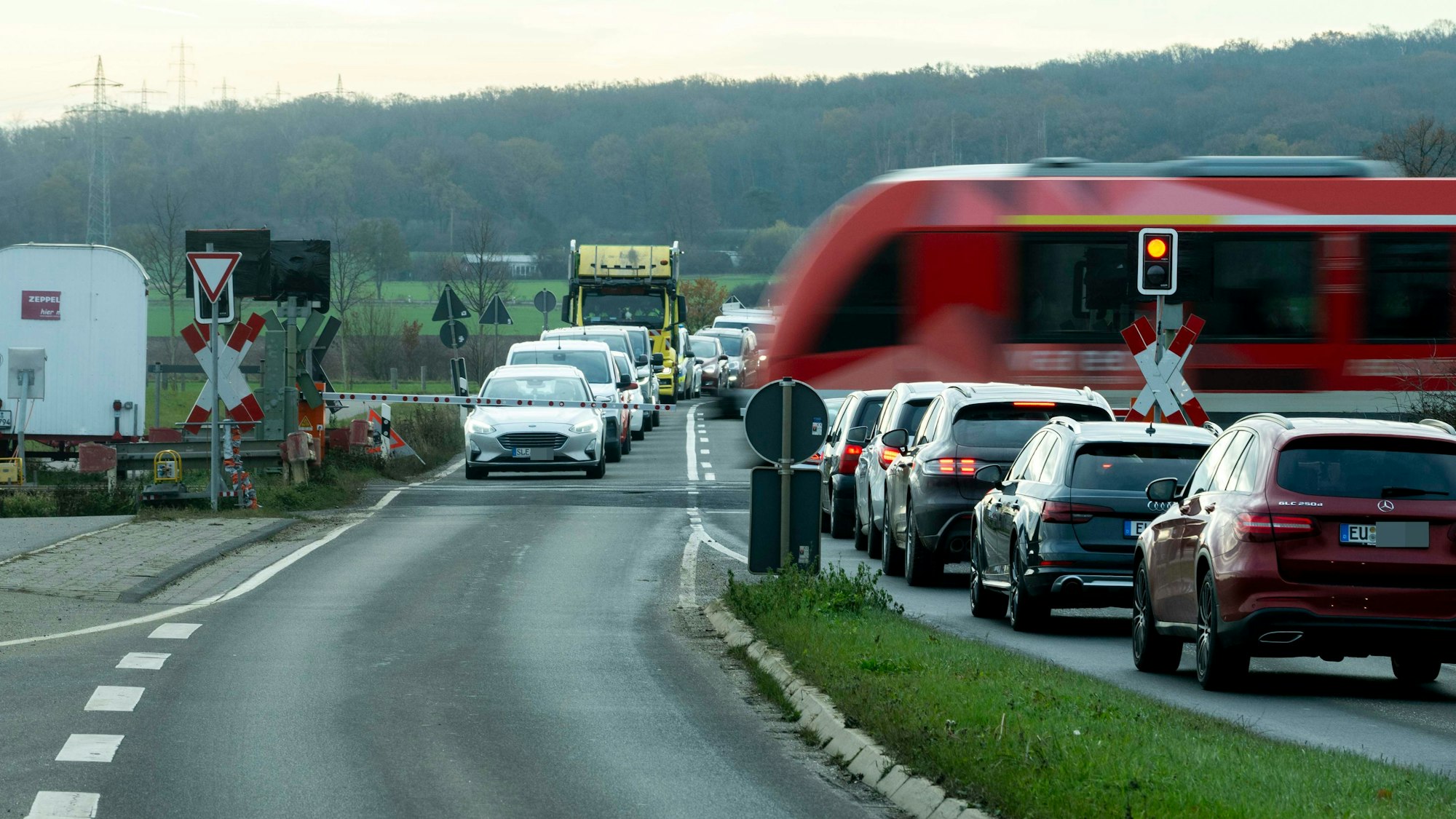 Das Bild zeigt den geschlossenen Bahnübergang in Euenheim. Vor den Schranken haben sich lange Warteschlangen gebildet.