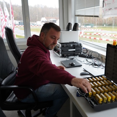 Das Foto zeigt einen Mann, der Transponder aus einem Koffer nimmt.