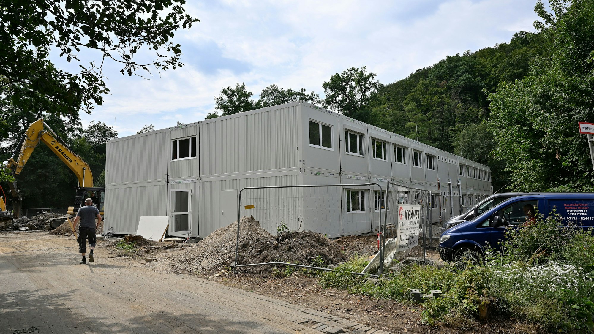 Ein Kran und mehrere Unterrichtscontainer stehen auf einem Baugelände.