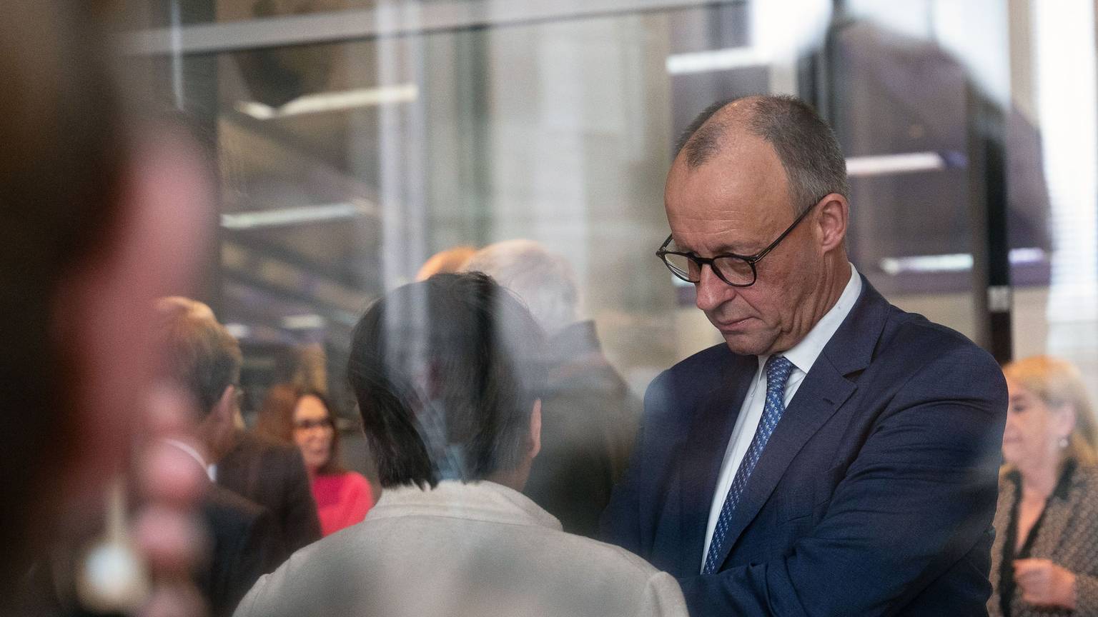 Bundeskanzler Friedrich Merz (r, CDU) im Gespräch mit Bundestagsabgeordneten bei einer namentlichen Abstimmung im Bundestag.