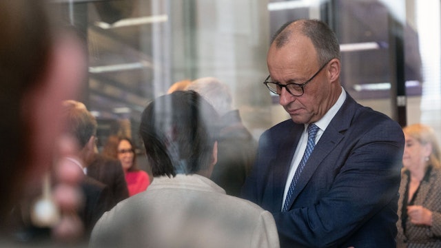 Bundeskanzler Friedrich Merz (r, CDU) im Gespräch mit Bundestagsabgeordneten bei einer namentlichen Abstimmung im Bundestag.