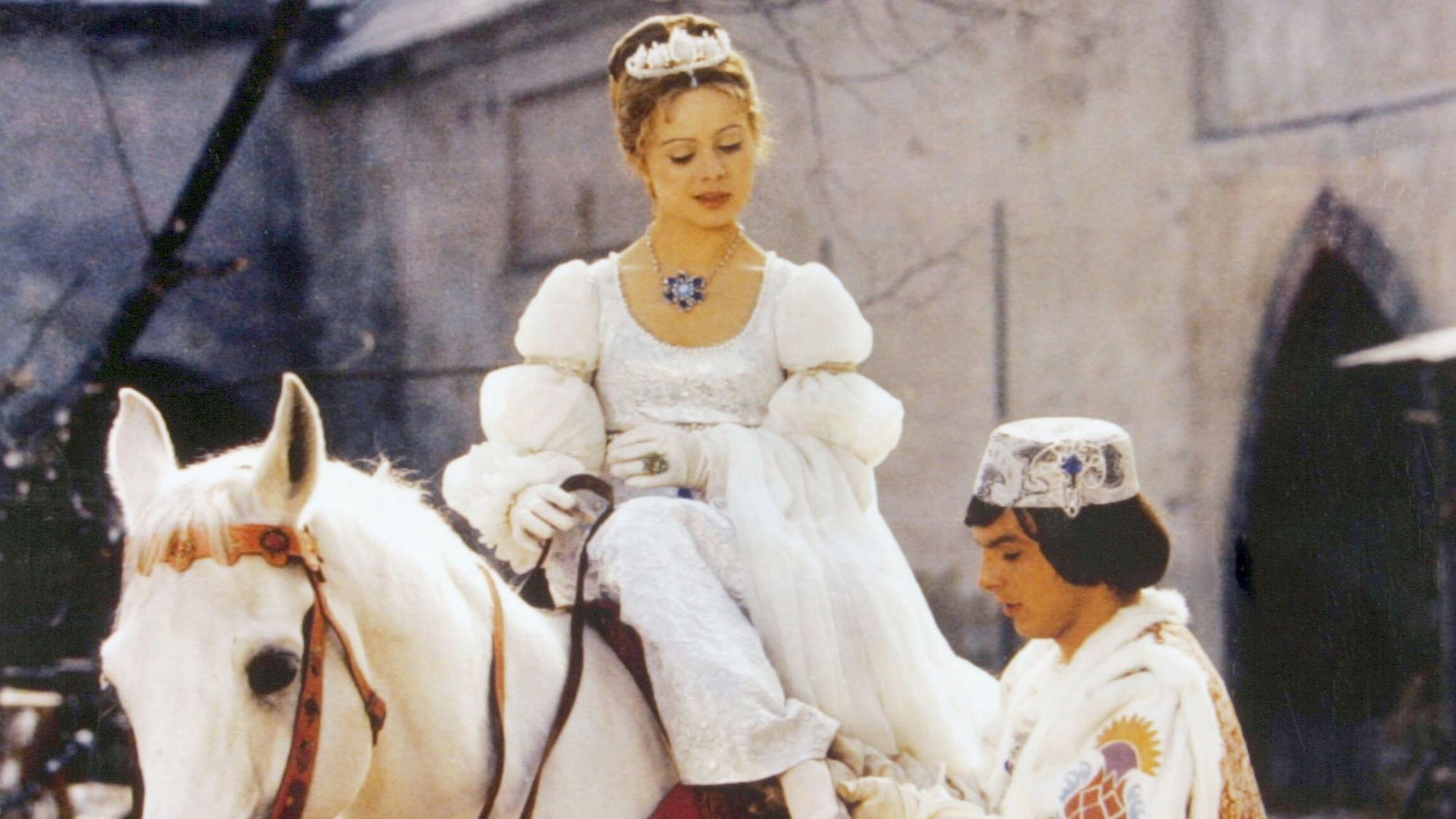 Aschenbrödel sitzt auf einem Schimmel, daneben steht der Prinz.